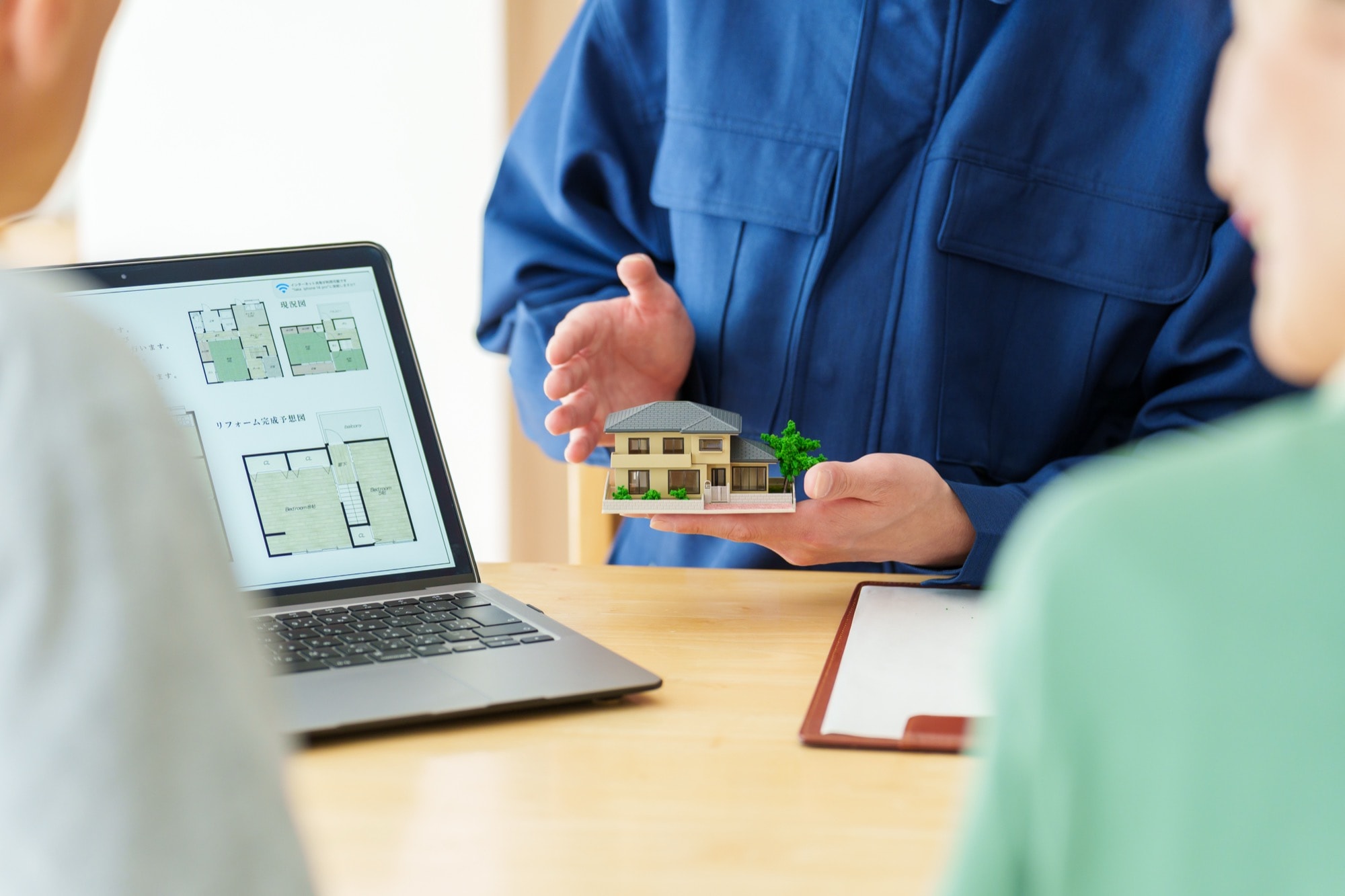 家の模型を使って解説をする建築士
