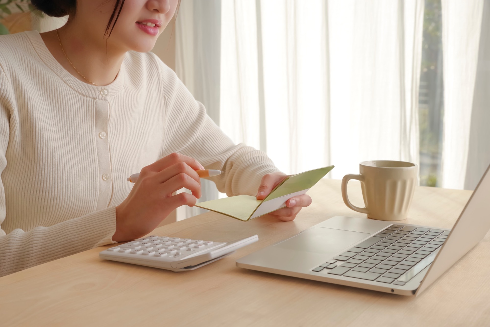 通帳をみてお金の管理をする女性
